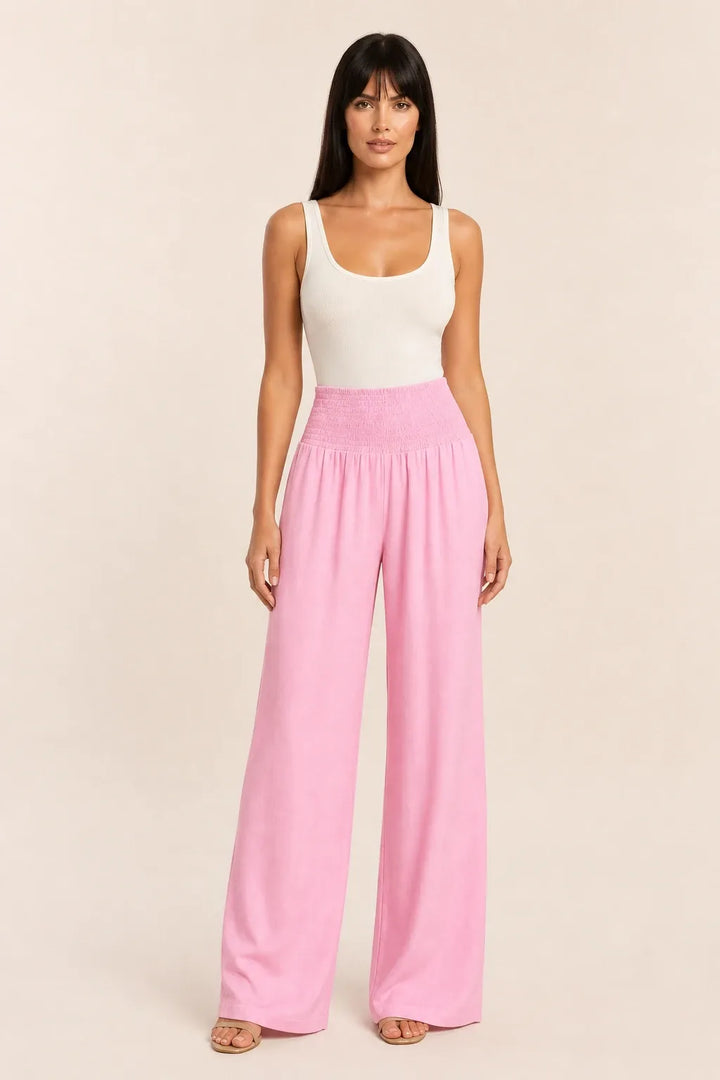 Pink smocked wide leg pants on model in contrapposto stance