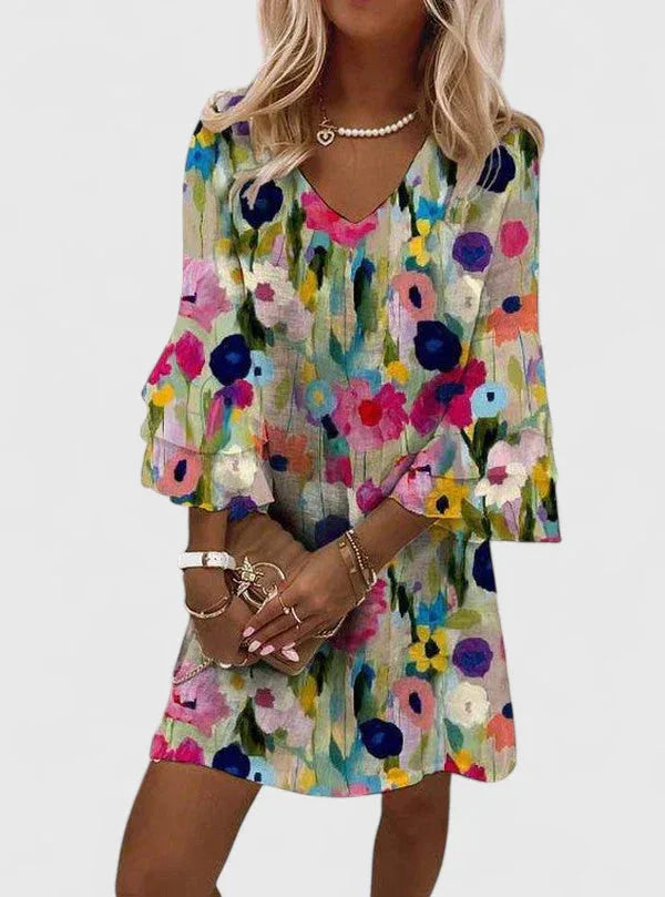 Woman wearing a floral multicolor mini dress with ruffle sleeves, facing forward