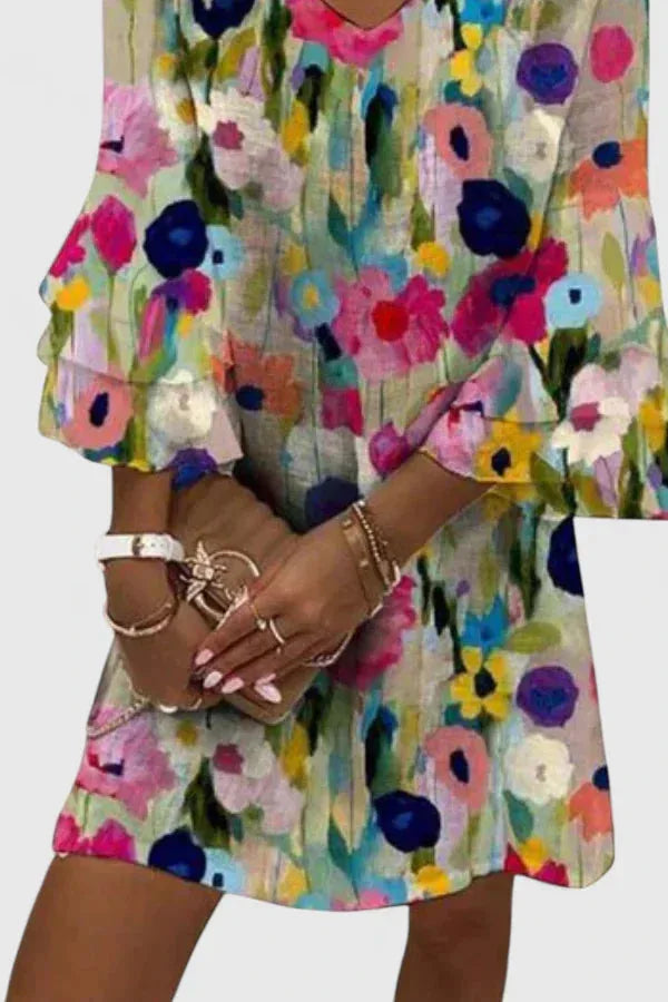 Woman wearing a floral multicolor ruffle sleeve mini dress, turned three-quarters