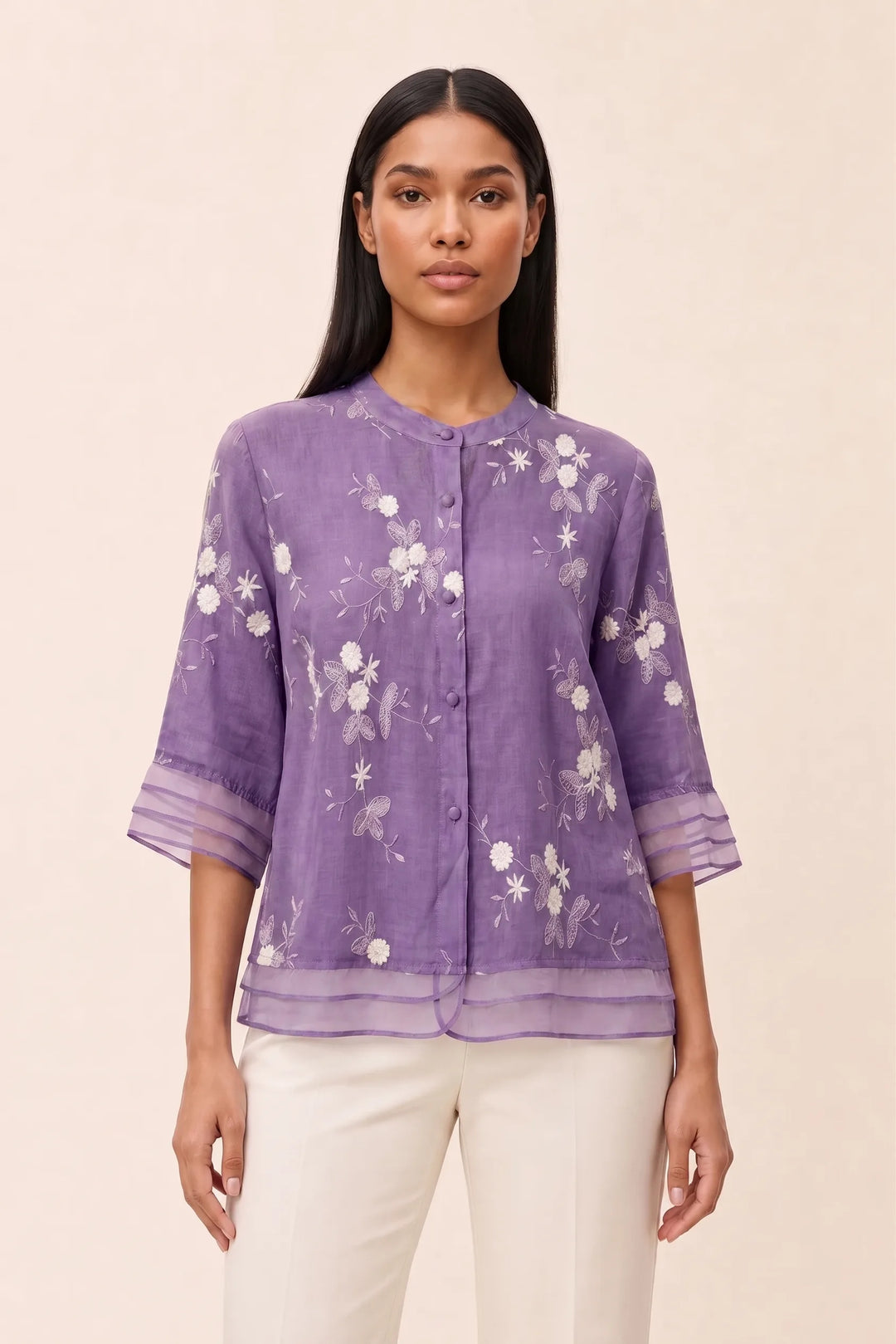 Lavender floral embroidered blouse on model in contrapposto stance