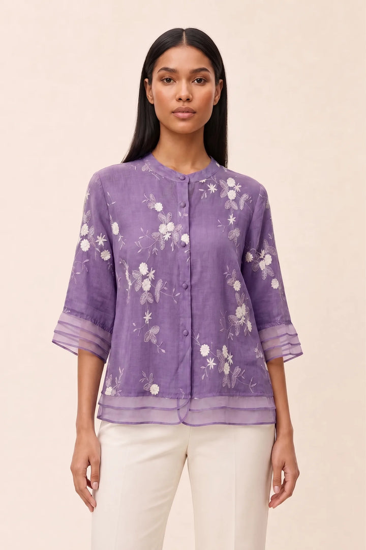 Lavender floral embroidered blouse on model in contrapposto stance