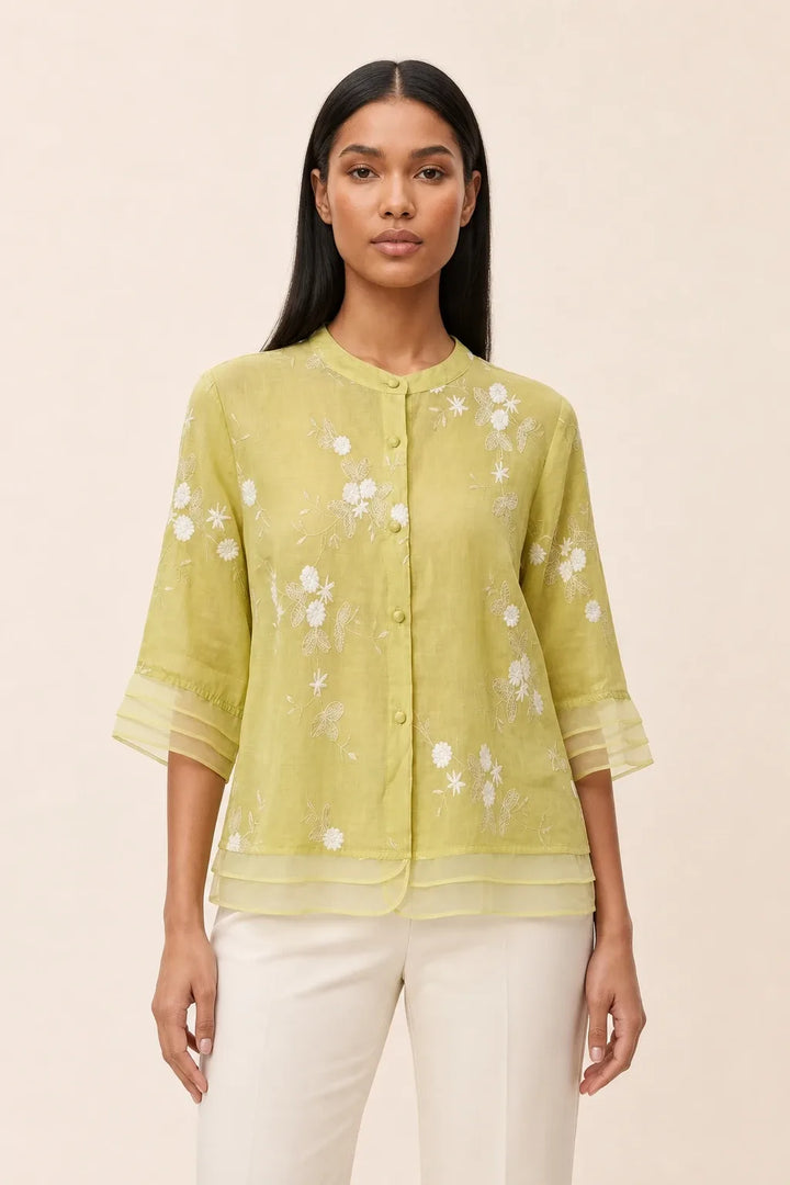 Yellow floral embroidered blouse on model in contrapposto stance