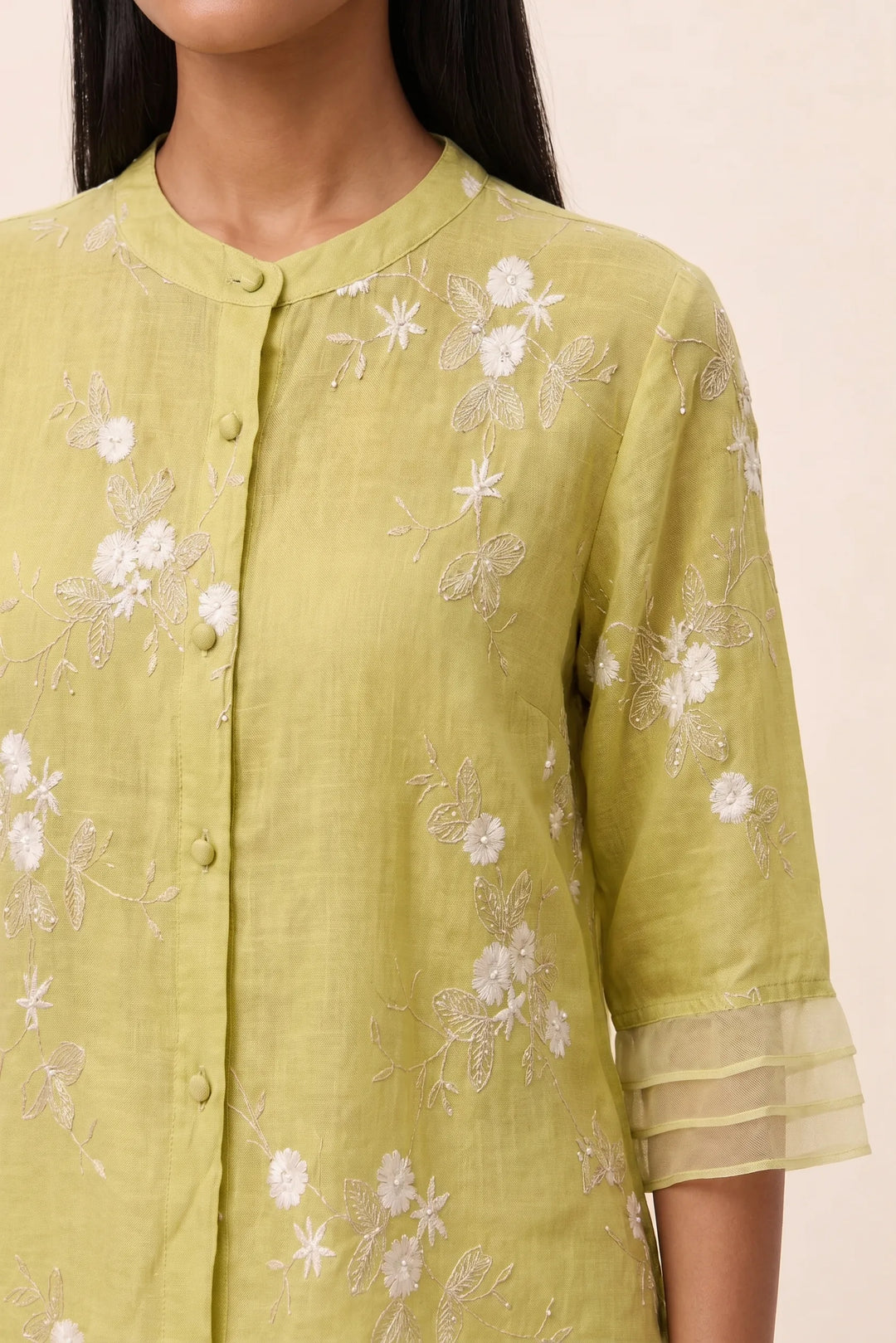 Close-up detail of floral embroidery on yellow blouse