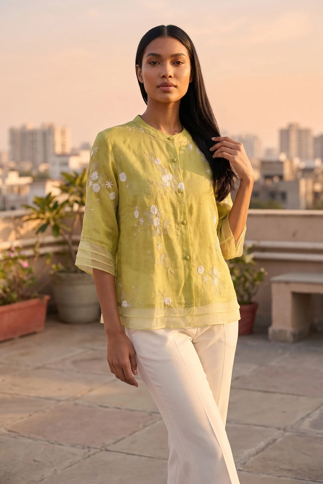 Model wearing yellow floral embroidered blouse in lifestyle setting