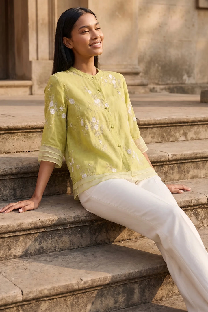 Model wearing yellow floral embroidered blouse in outdoor lifestyle setting