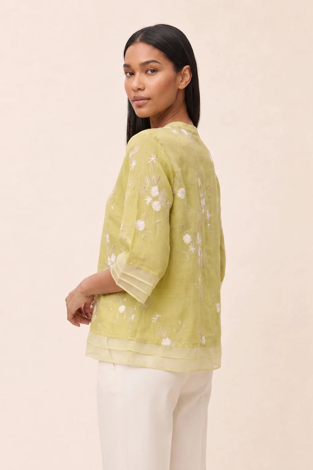 Yellow floral embroidered blouse on model in three-quarter turn