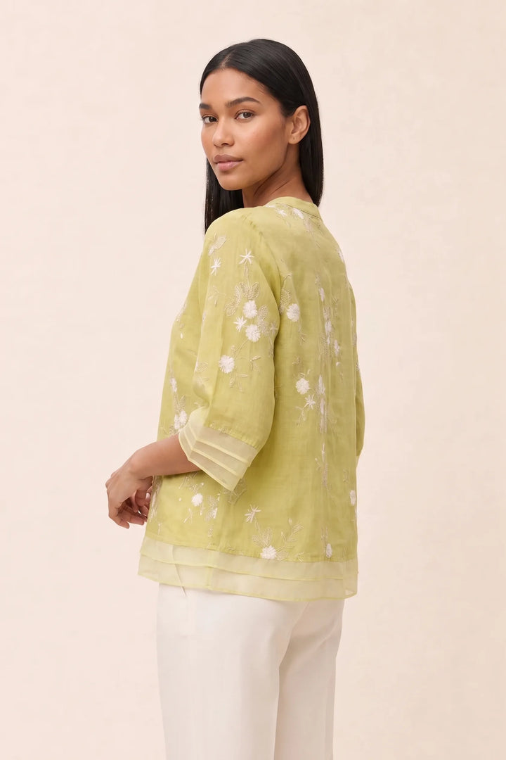 Yellow floral embroidered blouse on model in three-quarter turn