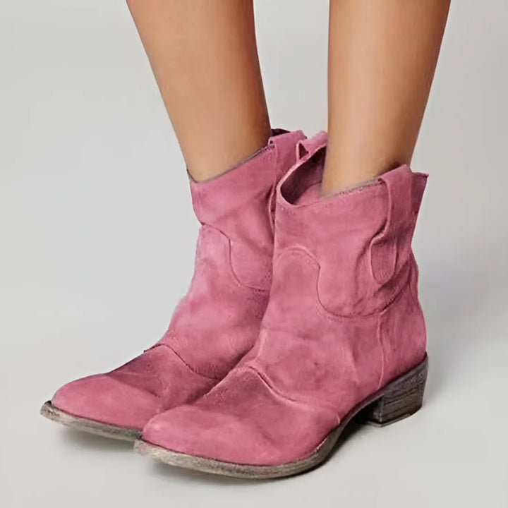 Pink western ankle boot, styled view showing pointed toe and decorative stitching