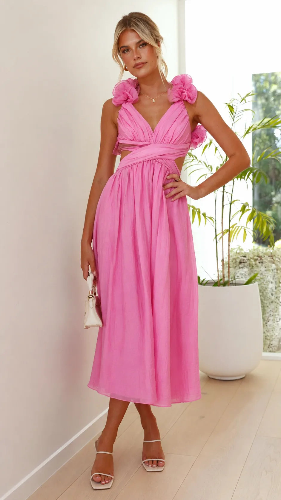 Close-up detail of ruffle trim and lace-up corseting on a pink midi dress