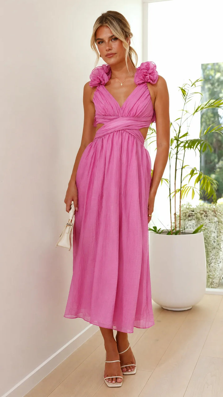Model in side profile wearing a pink ruffle midi dress with lace-up back