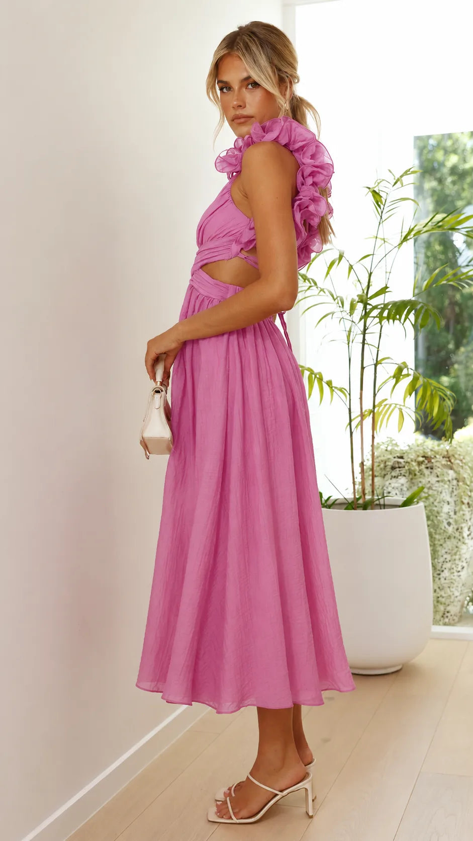 Model at a three-quarter turn in a pink ruffle lace-up midi dress