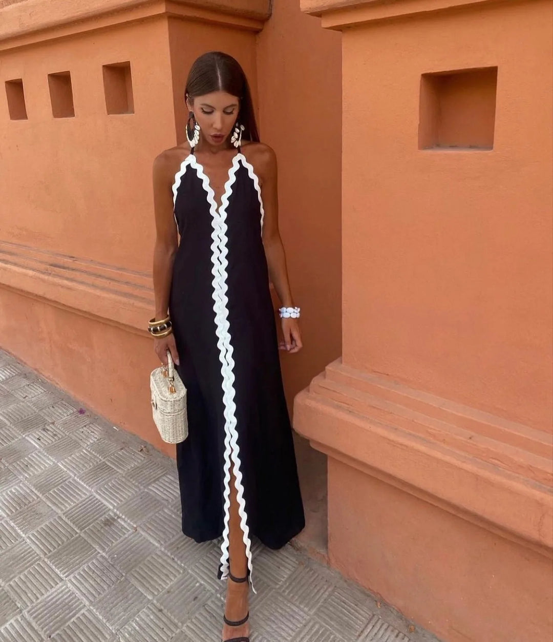 Woman facing forward in a black maxi dress with ric rac trim details