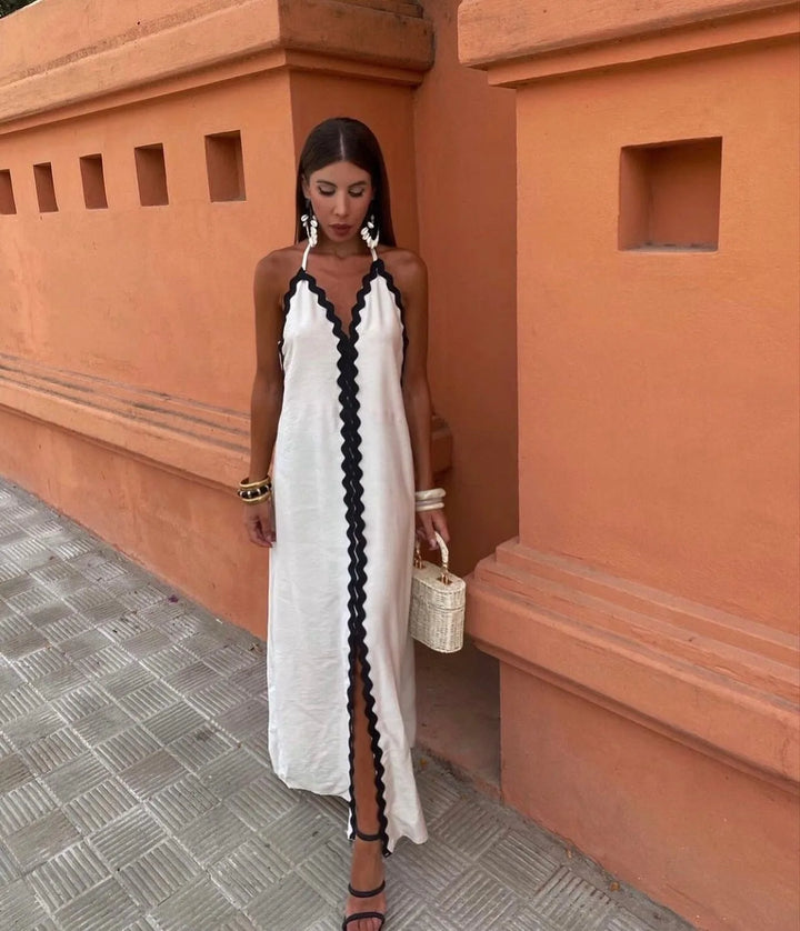 Woman in a three-quarter turn wearing a white ric rac-trimmed maxi dress