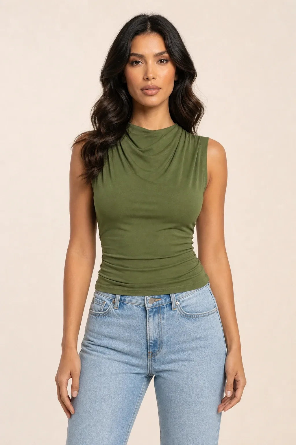 Green draped cowl neck top on a model in a contrapposto stance
