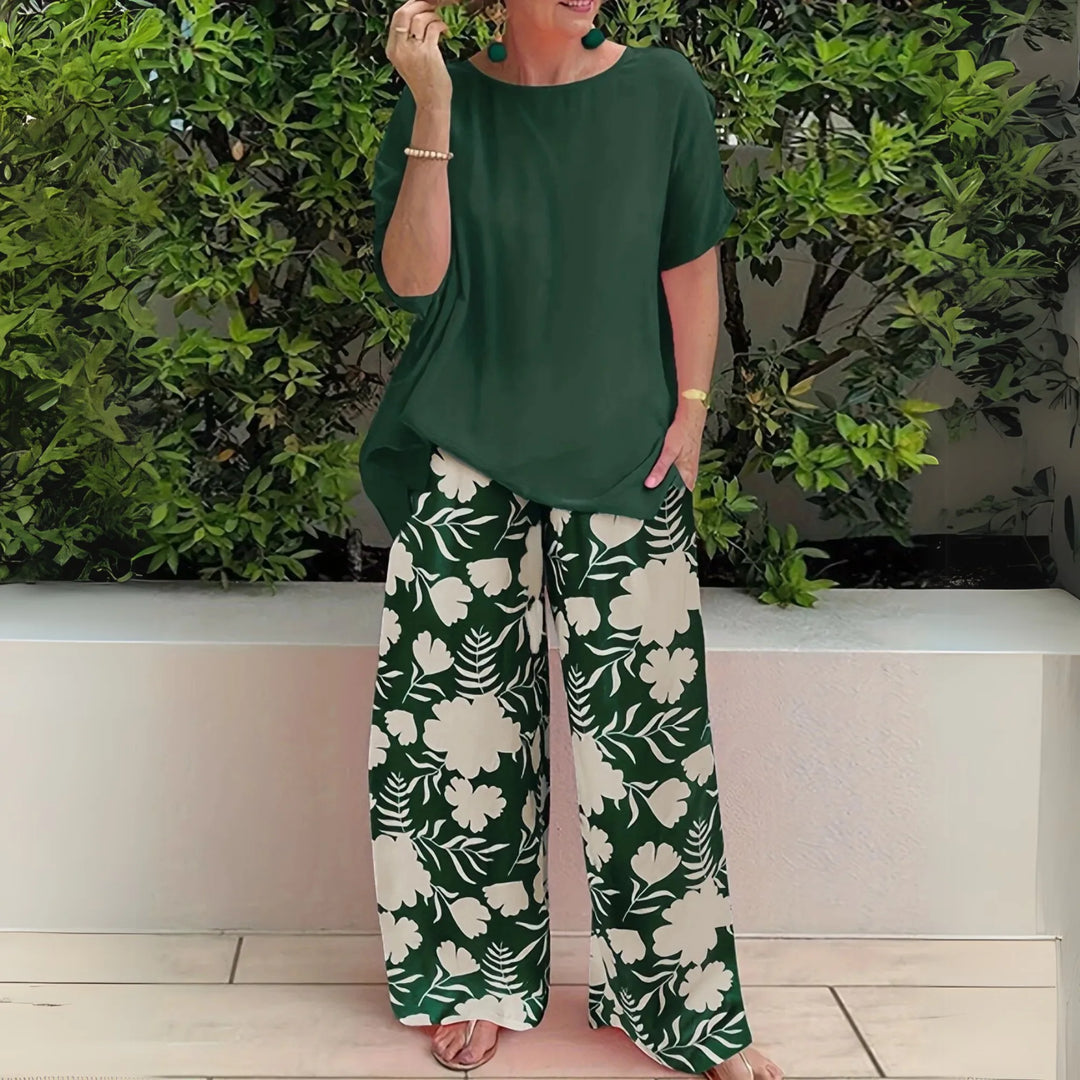 Woman facing forward in forest green floral wide-leg trousers and matching top