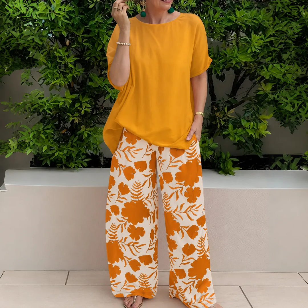 Close-up detail of mandarin orange floral wide-leg trousers and coordinating top