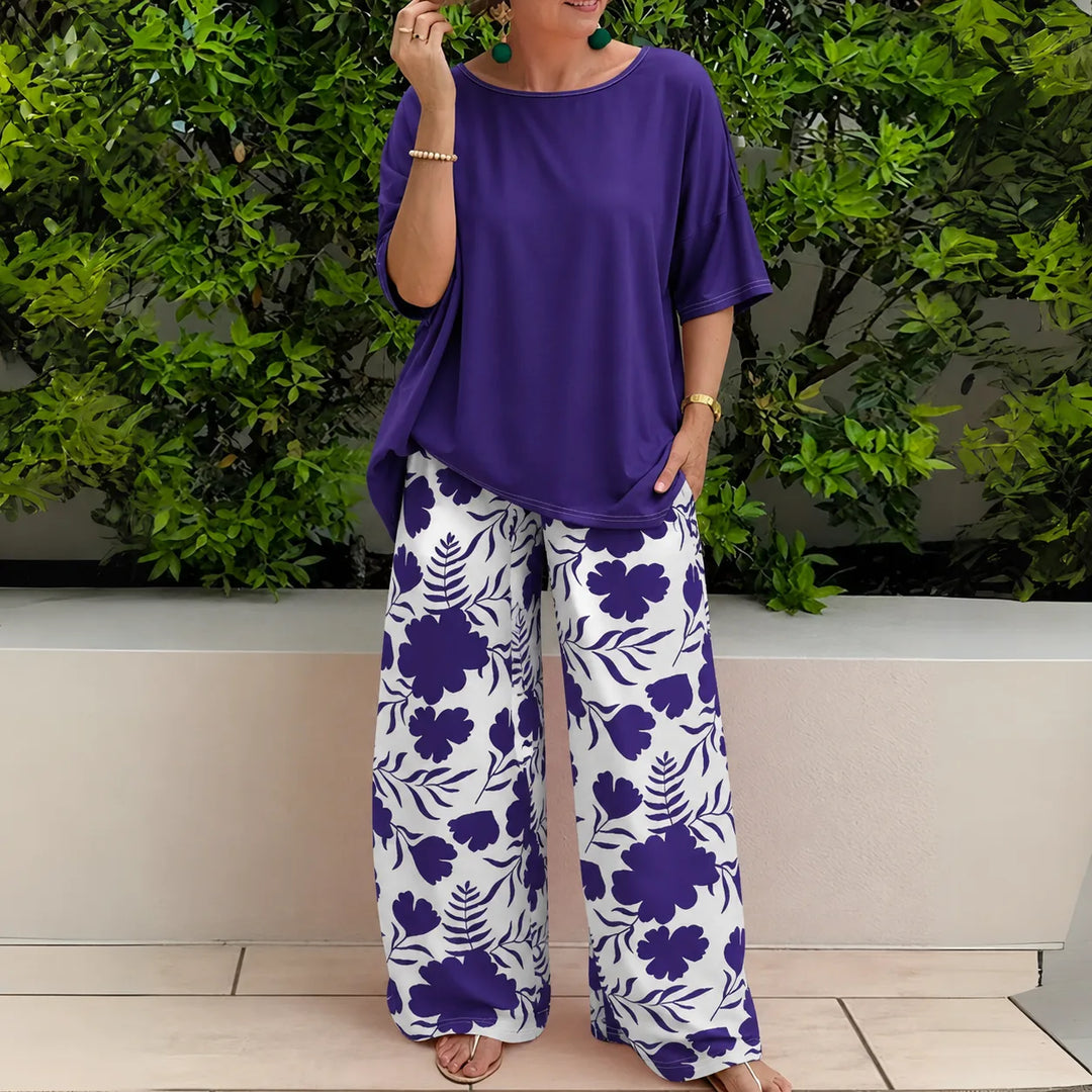 Woman in side profile wearing navy blue floral wide-leg trousers and matching top