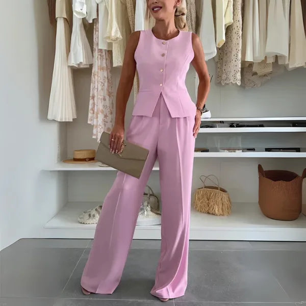 Model in a pink vest trouser suit, posed sideways to reveal silhouette