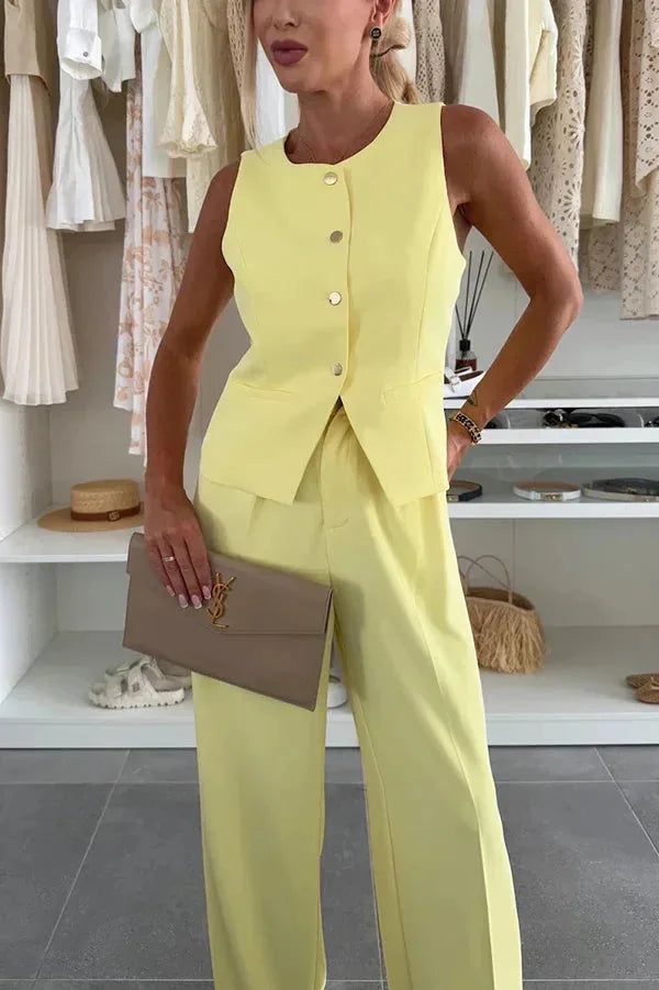 Model wearing a yellow sleeveless vest and wide-leg trousers, standing facing forward