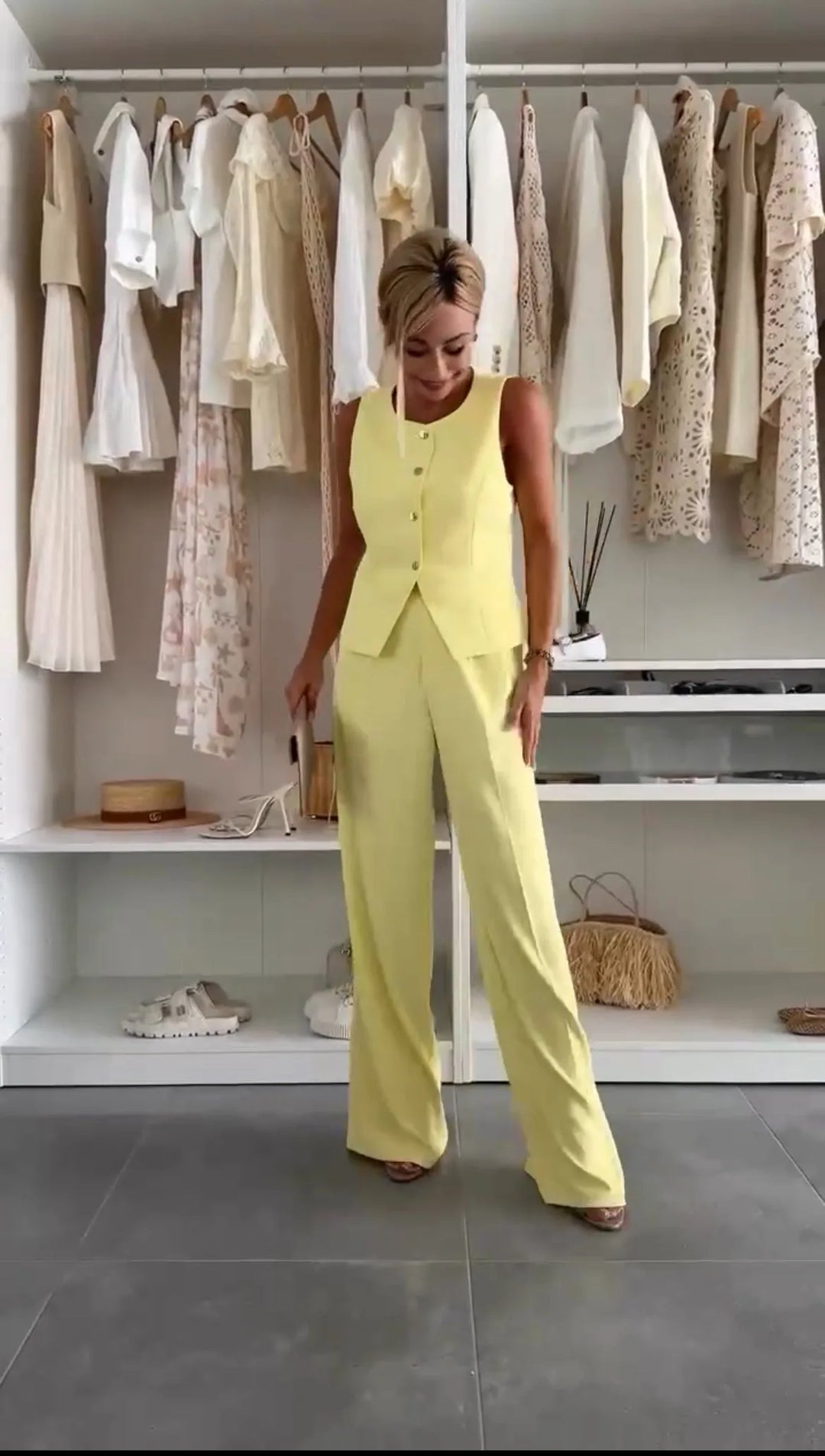 Model in a yellow vest trouser suit, turned three-quarters to show cut and fit