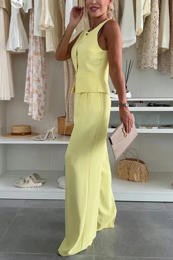 Model styled in a yellow vest trouser suit captured in a relaxed standing pose