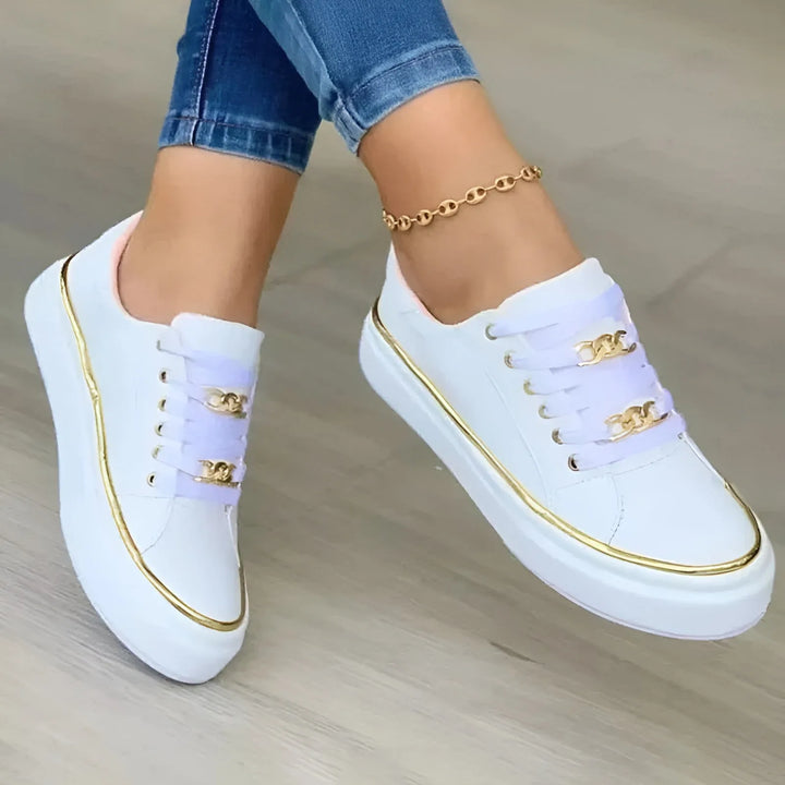 White platform sneaker with gold chain detail, front view