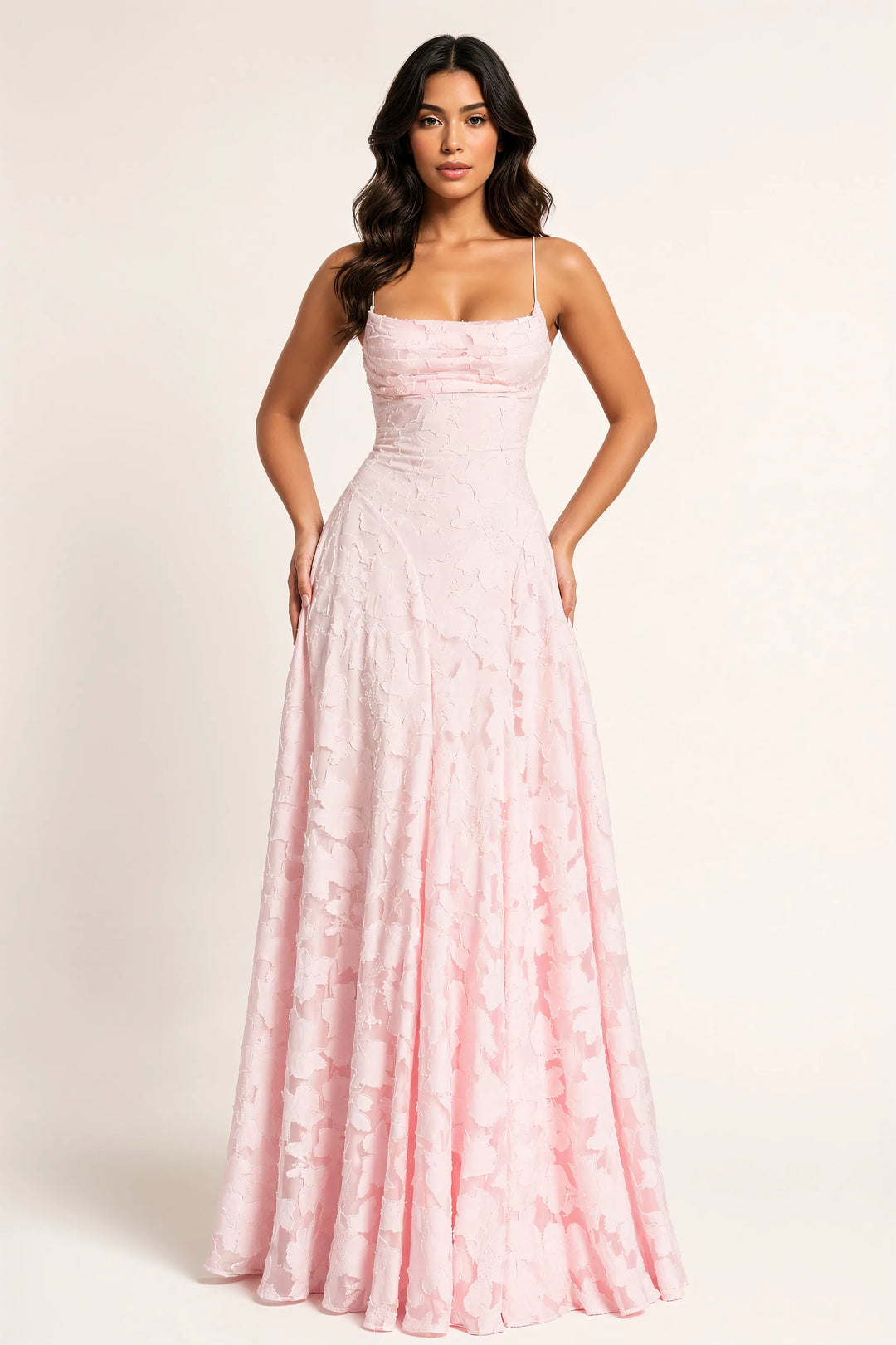 Pink floral appliqué maxi gown on a model in a contrapposto stance