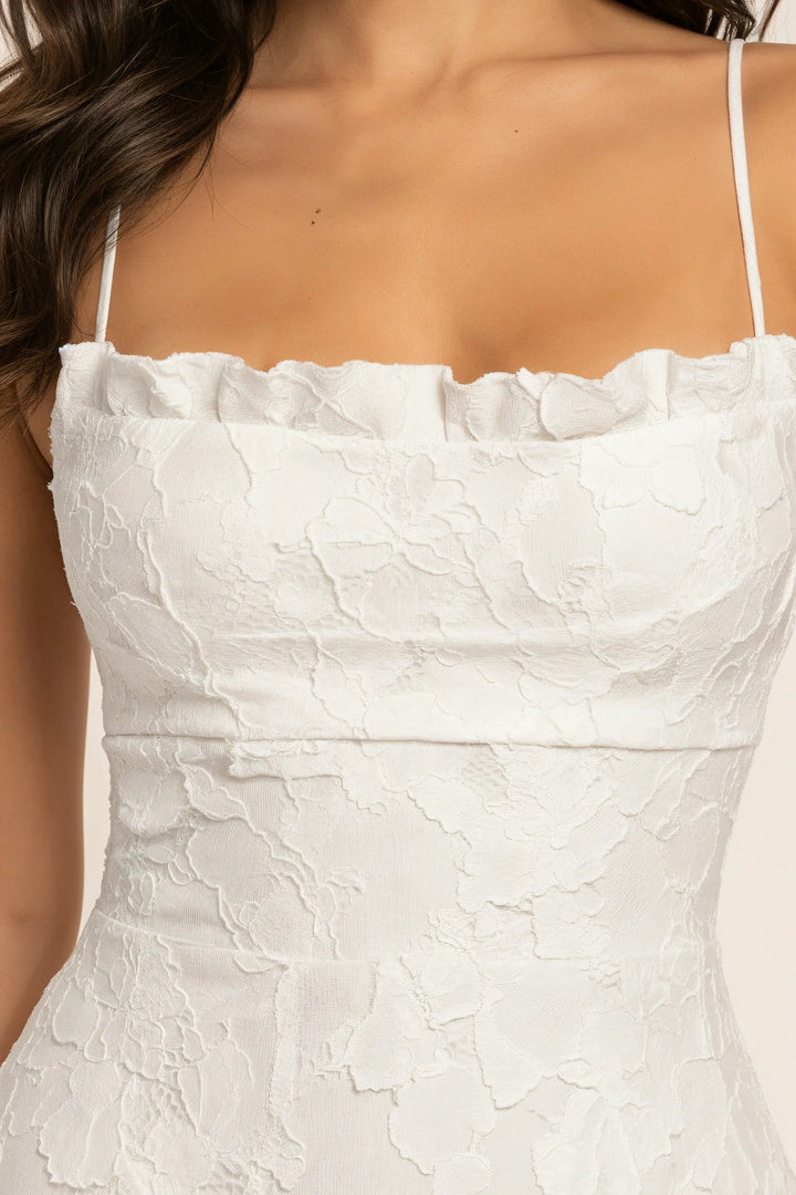 Close-up detail of floral appliqué embellishment on a white maxi gown