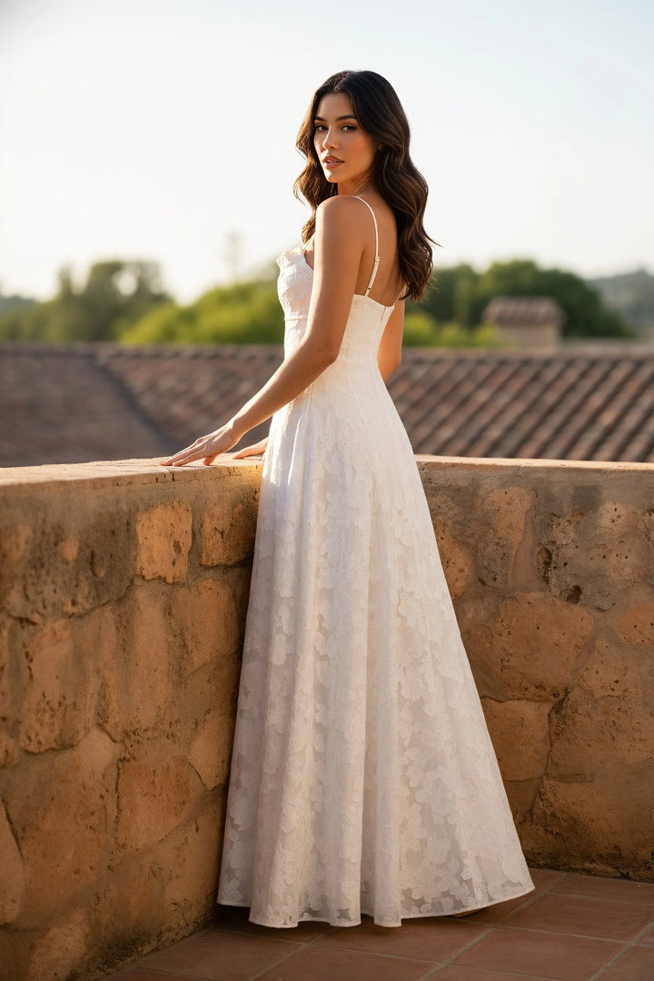 Model wearing a white floral appliqué maxi gown in a lifestyle setting