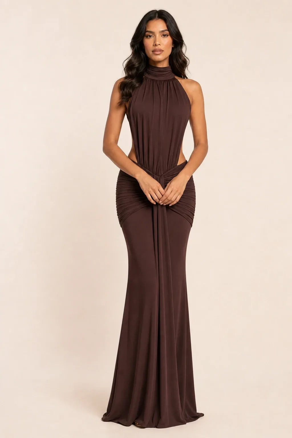 Floor-length ruched backless gown in coffee brown worn by a model in a contrapposto stance