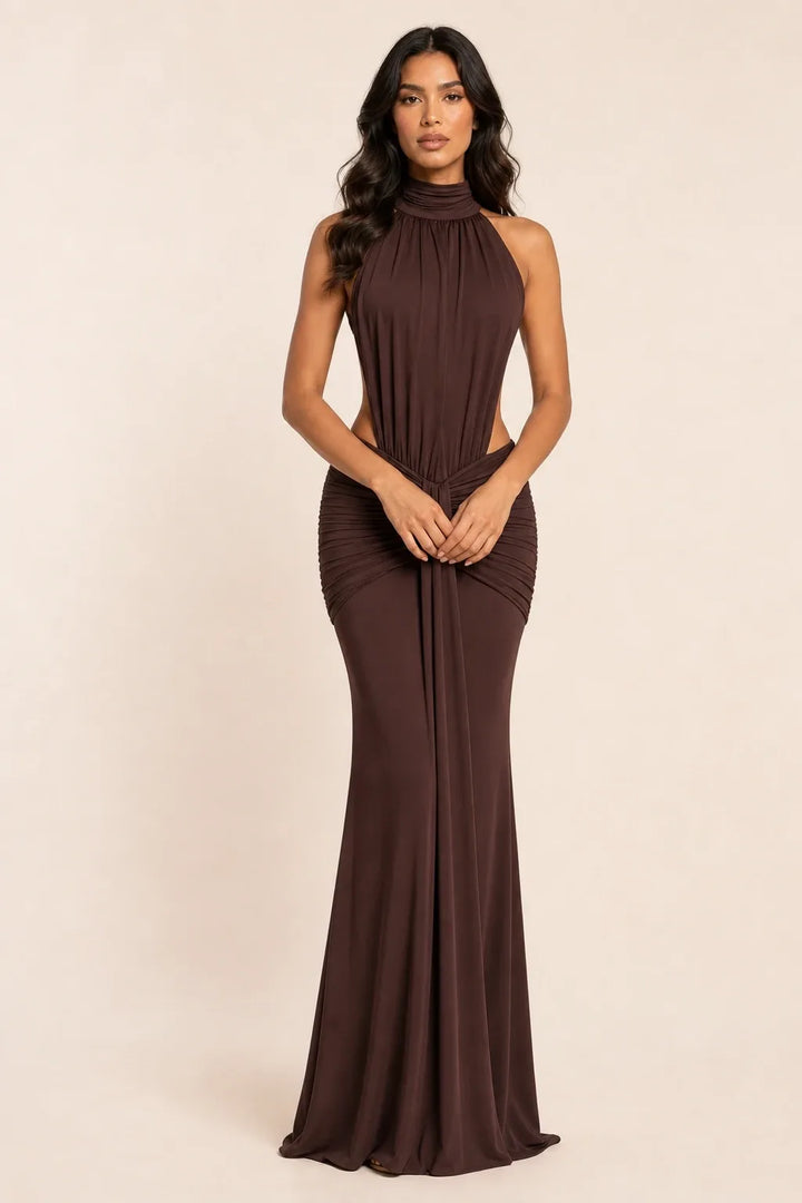 Floor-length ruched backless gown in coffee brown worn by a model in a contrapposto stance