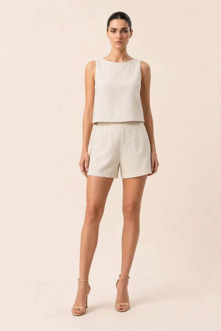 Woman in apricot crop top and matching shorts standing in contrapposto pose