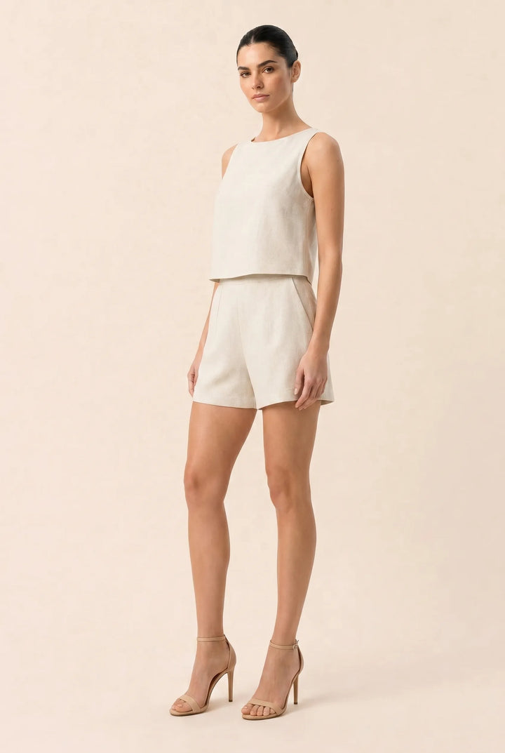 Woman in apricot crop and shorts set shown at a three-quarter angle turn