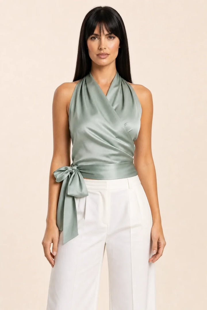 Green satin halter wrap top on model in contrapposto stance
