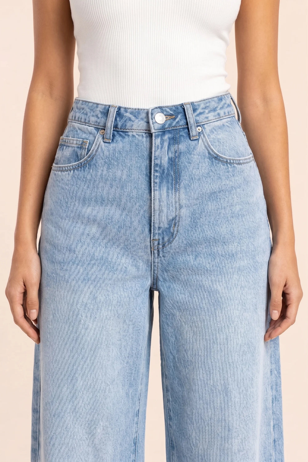 Close-up detail of wide-leg blue denim fabric and stitching