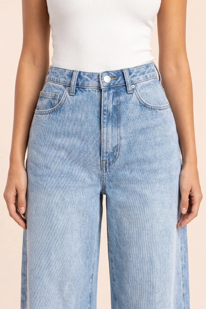 Close-up detail of wide-leg blue denim fabric and stitching
