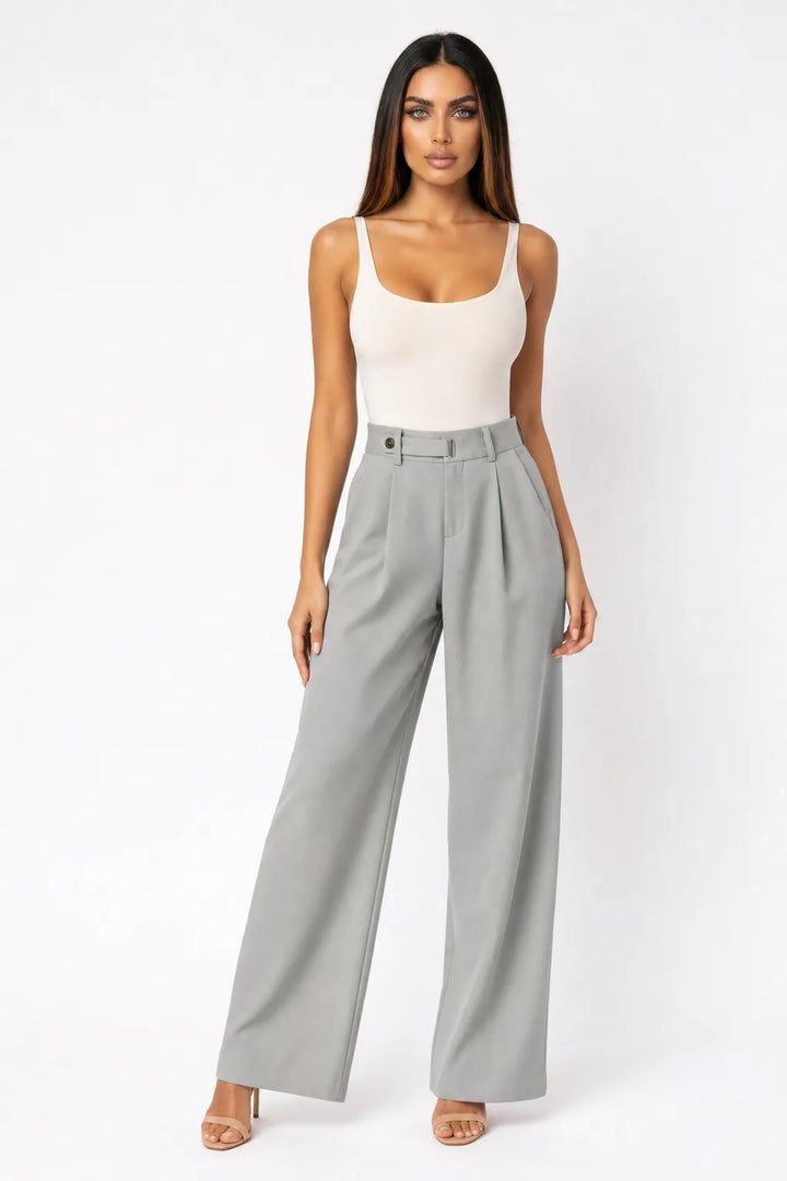 Grey pleated wide-leg trousers on a model in a contrapposto stance