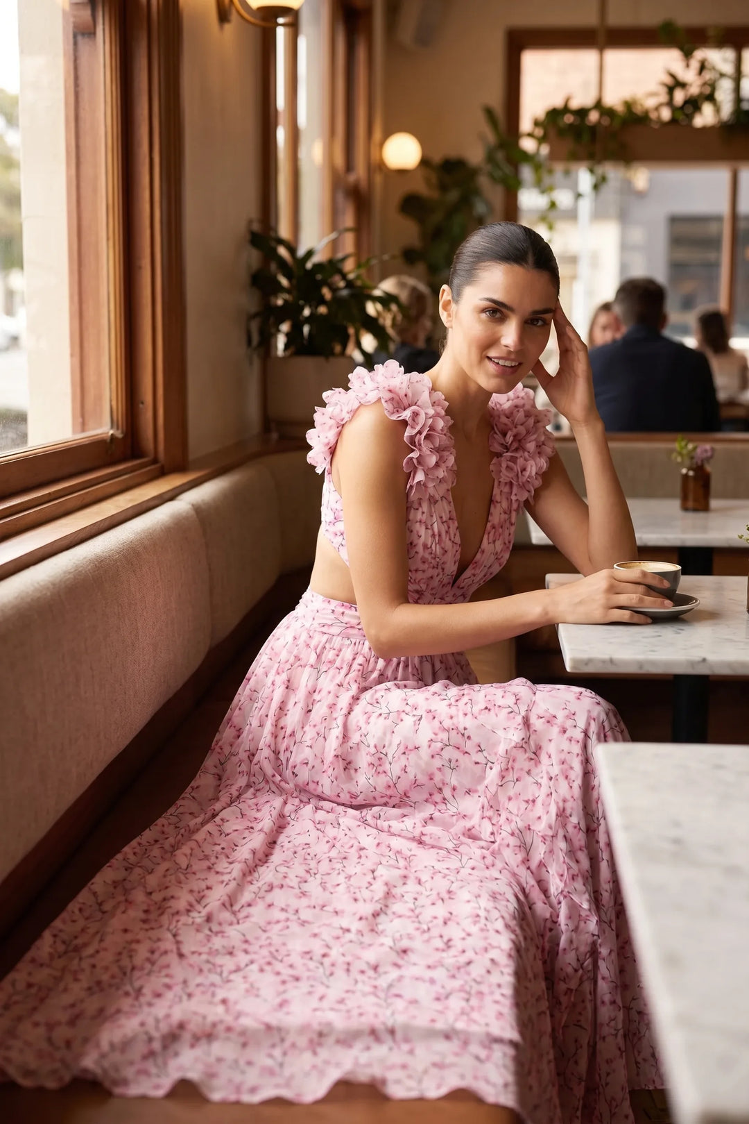 Model in pink ruffle-shoulder maxi dress in outdoor lifestyle scene