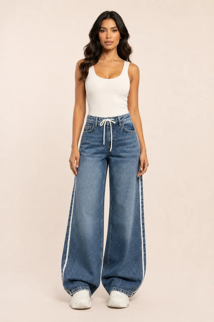 Medium blue wide-leg jeans with white side stripes on a model in a contrapposto stance