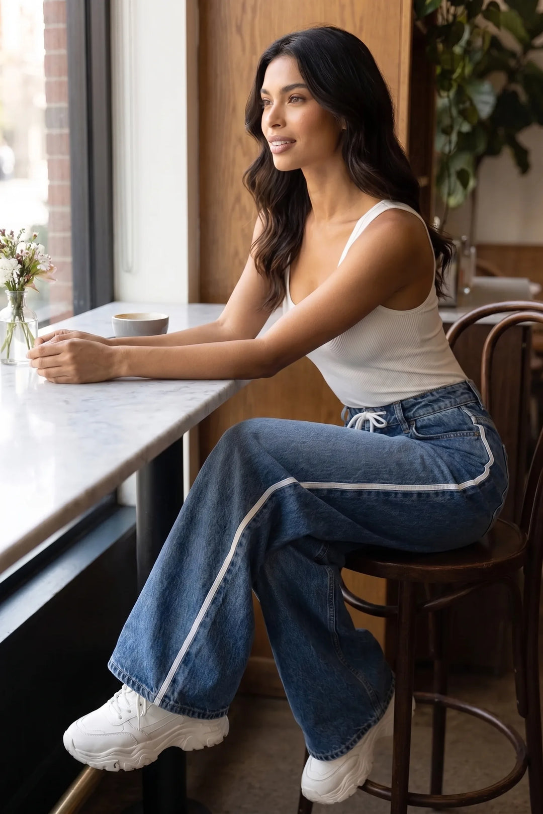 Model styled in medium blue wide-leg side-stripe jeans in a casual lifestyle scene