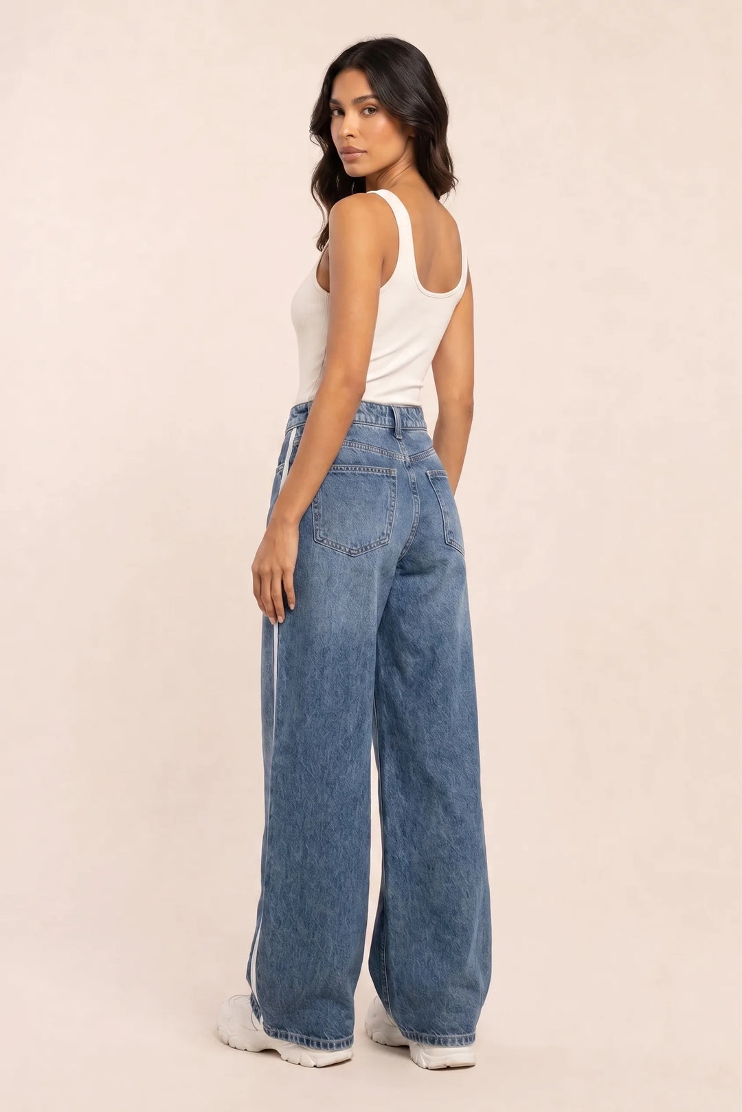 Medium blue wide-leg striped jeans on a model in a three-quarter turn pose