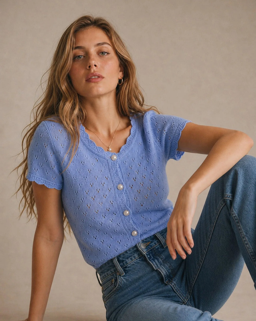Side view of a woman in a blue knit top with pearl button detail