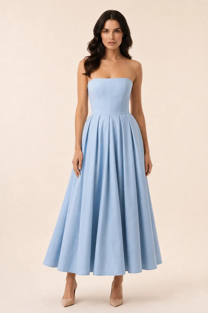 Blue strapless pleated midi dress on model in contrapposto stance