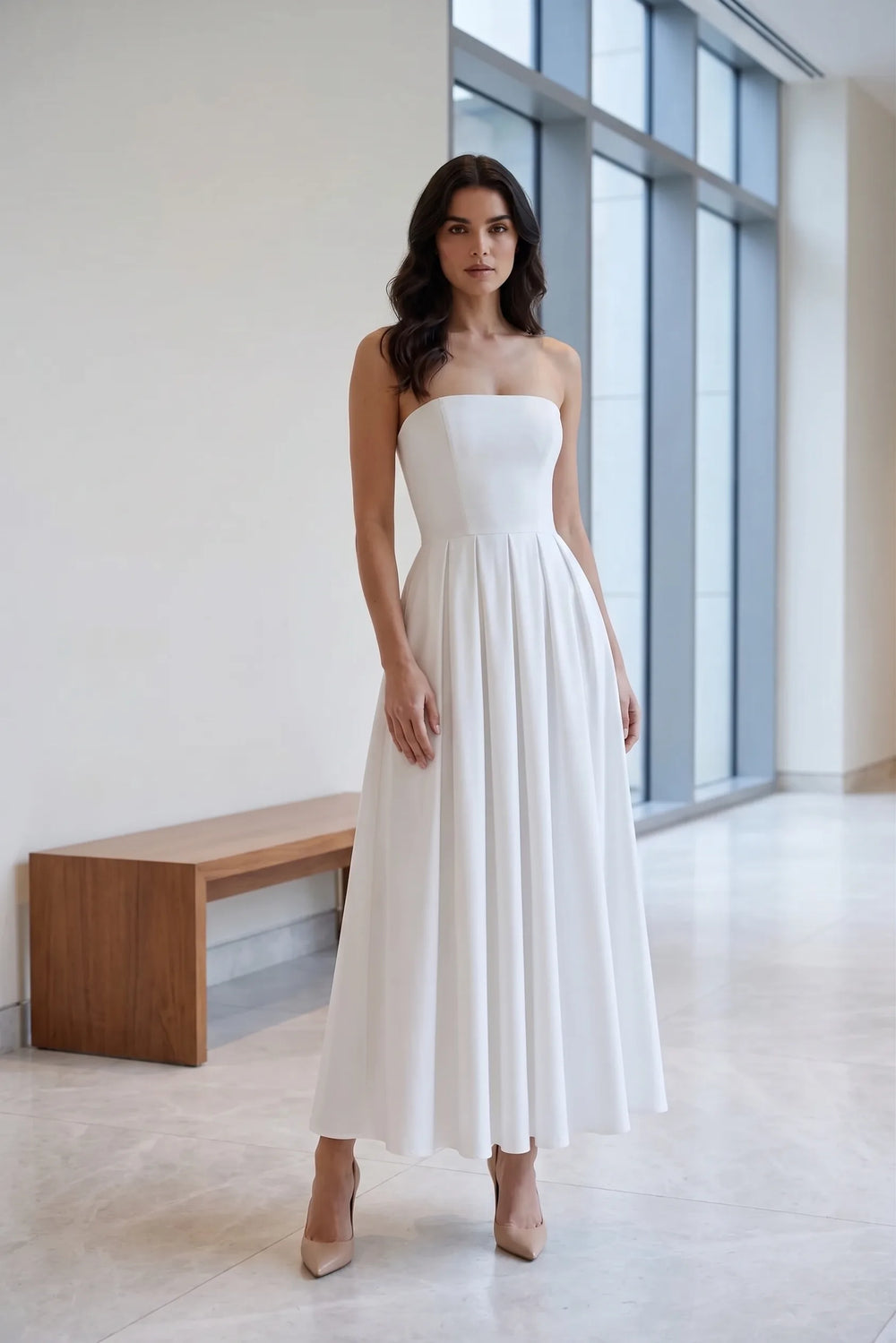 Model wearing white strapless pleated midi dress in lifestyle setting