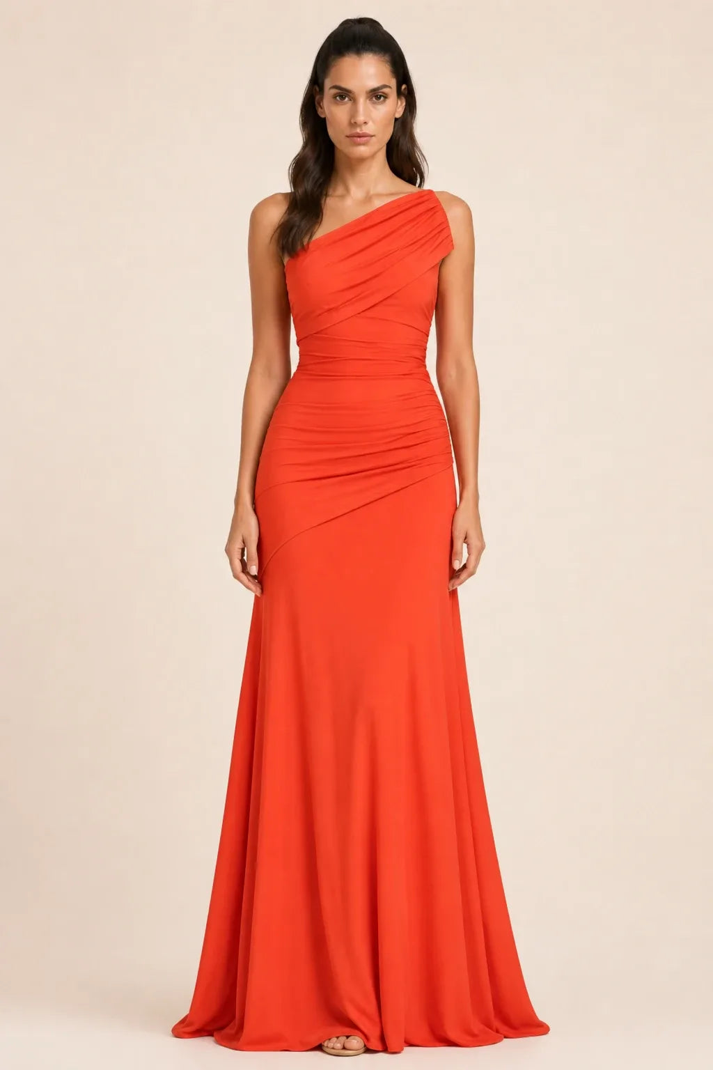 Woman in an orange ruched-shoulder maxi gown standing in a contrapposto pose