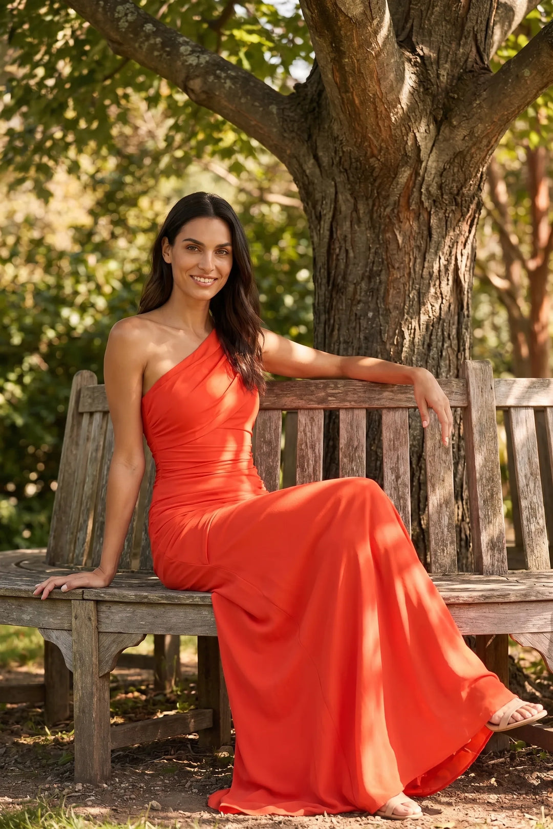 Woman in an orange ruched-shoulder maxi gown styled in an outdoor lifestyle scene