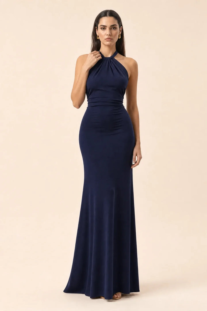Navy blue twisted knot halter maxi dress on model in contrapposto stance