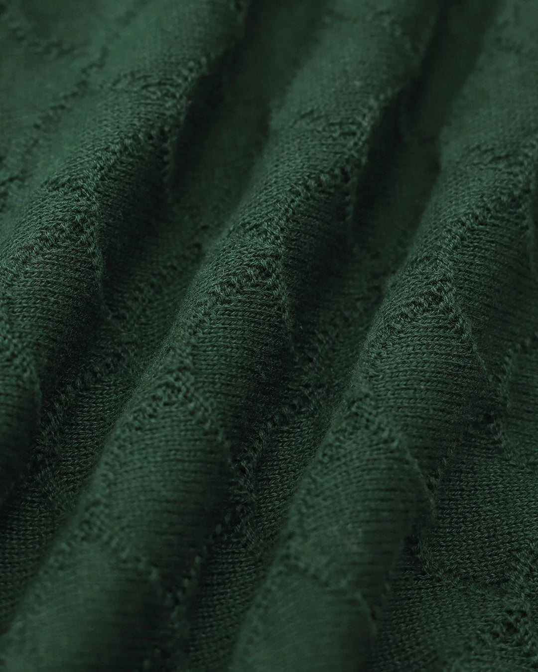 Dark green knit polo top with pearl button placket, model styled view