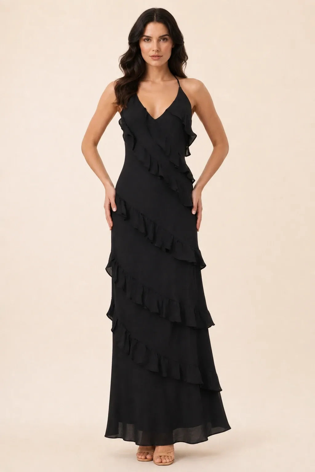 Black tiered ruffle halter maxi dress on a model in a contrapposto stance