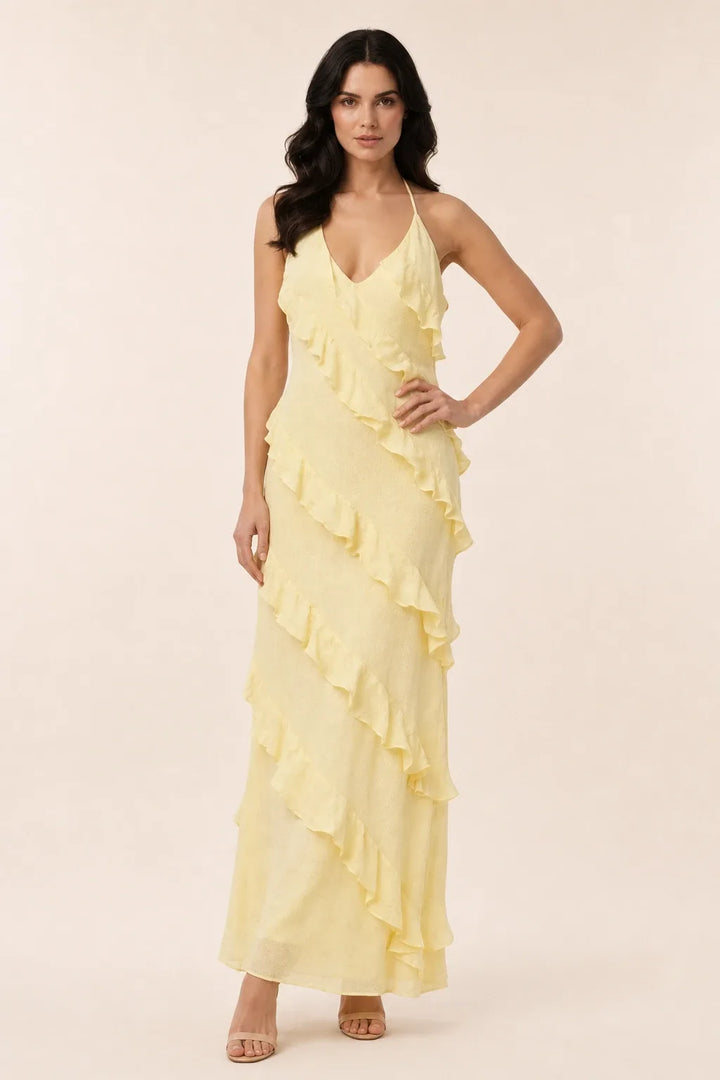 Yellow tiered ruffle halter maxi dress on a model in a contrapposto stance
